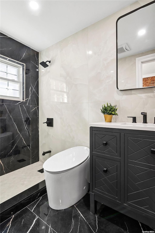 bathroom featuring a tile shower, vanity, tile walls, and toilet