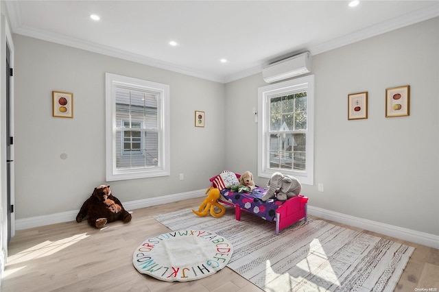 rec room with a wall mounted air conditioner, light wood-type flooring, and crown molding