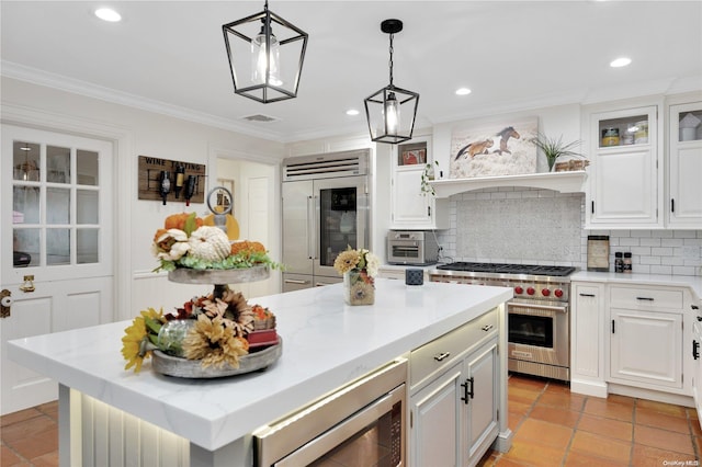 11A Sunken Meadow Rd Unit A, Northport, NY 11768 - kitchen with built in appliances, tasteful backsplash, a kitchen island, ornamental molding, and white cabinets