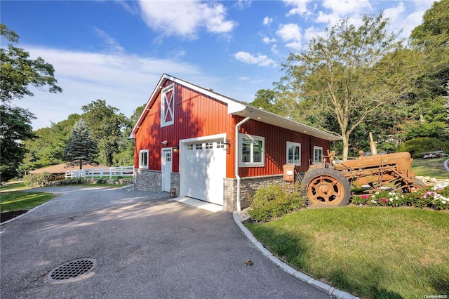 exterior space featuring a garage and an outbuilding