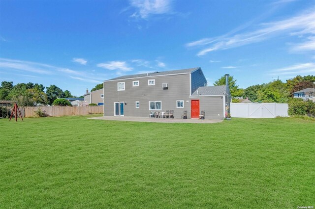 rear view of house featuring a lawn and a patio