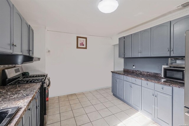 kitchen featuring gray cabinetry, light tile patterned floors, and appliances with stainless steel finishes