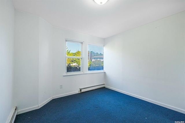 carpeted spare room with a baseboard heating unit