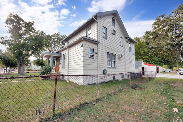 view of side of home with a lawn and a wall mounted AC