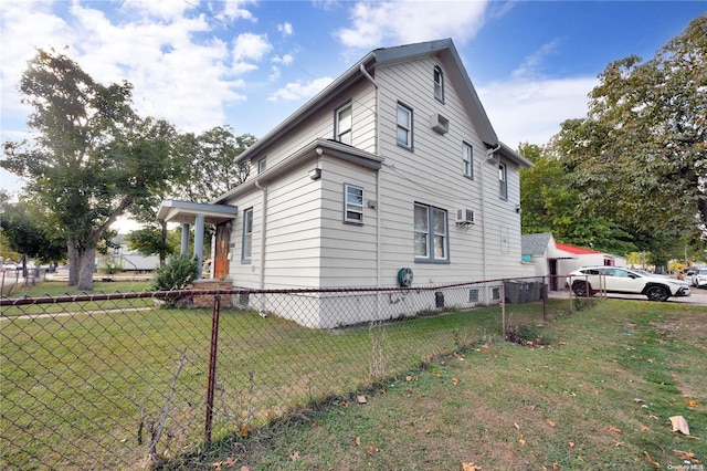 view of side of property with a yard and a wall unit AC