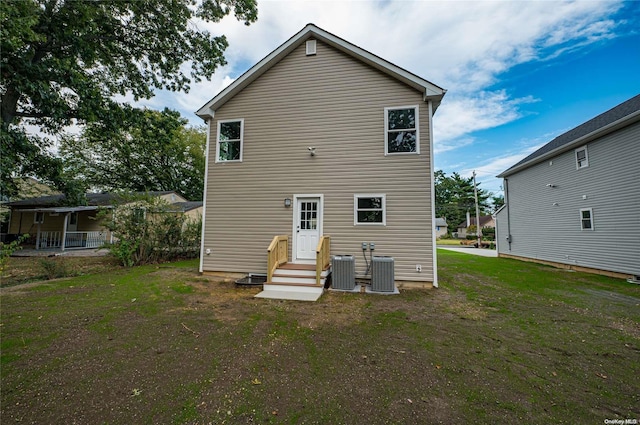 rear view of house featuring a yard and central AC