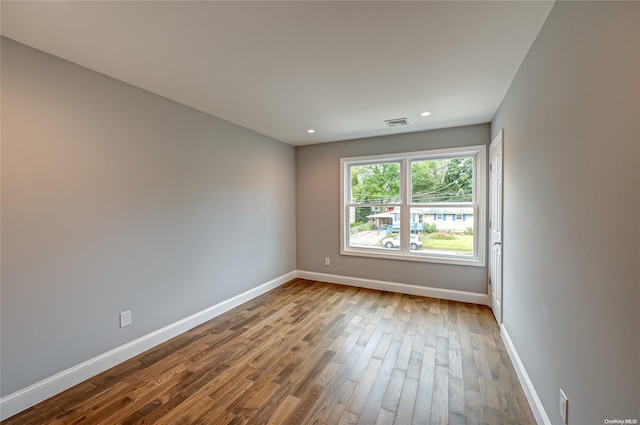 unfurnished room with hardwood / wood-style flooring