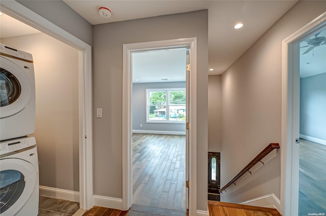 washroom with stacked washer / dryer and dark wood-type flooring