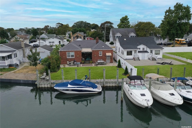 rear view of property featuring a water view and a yard