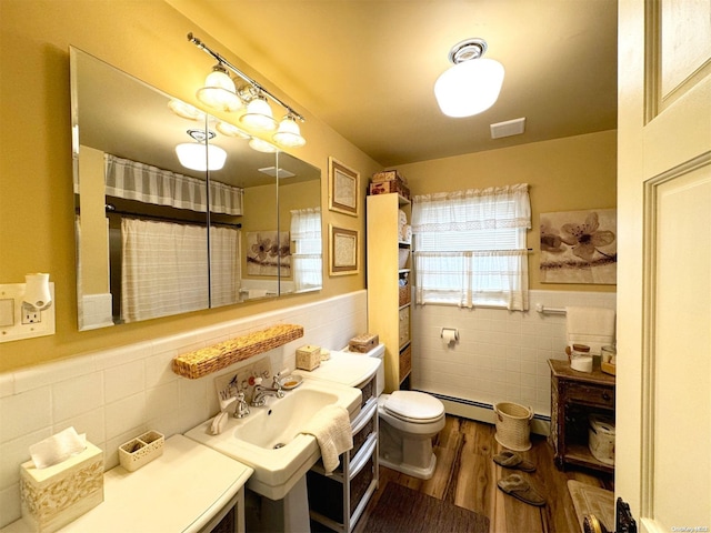 bathroom featuring curtained shower, a baseboard radiator, wood-type flooring, toilet, and tile walls