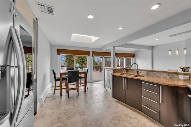 kitchen featuring sink, hanging light fixtures, a skylight, dark brown cabinetry, and stainless steel appliances