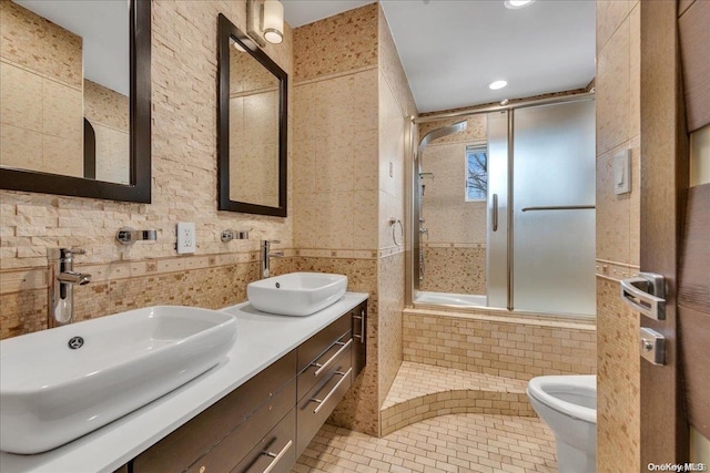 full bathroom with tile patterned floors, bath / shower combo with glass door, vanity, tile walls, and toilet