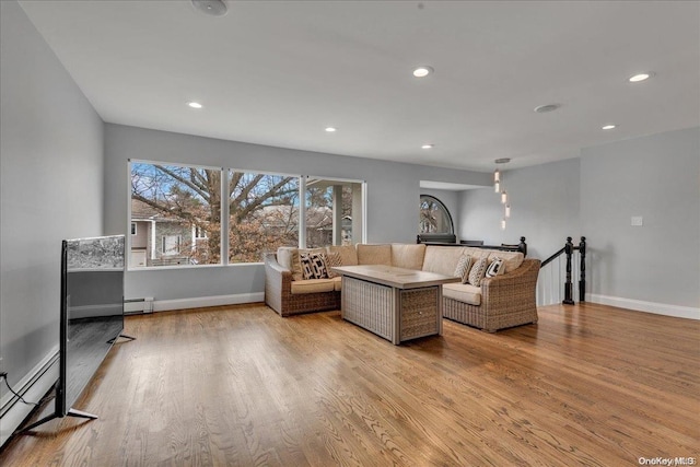 living room with baseboard heating and light hardwood / wood-style flooring