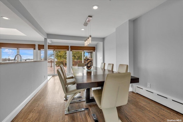 dining area featuring dark wood-type flooring and a baseboard heating unit