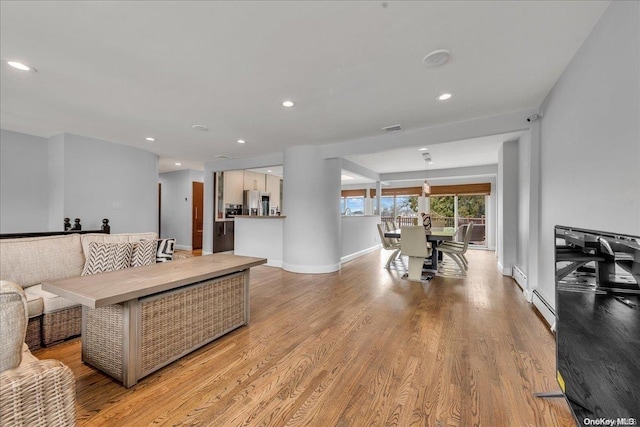 living room featuring a baseboard radiator and light wood-type flooring