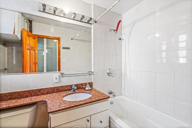 full bathroom featuring backsplash, vanity, tile walls, toilet, and tiled shower / bath