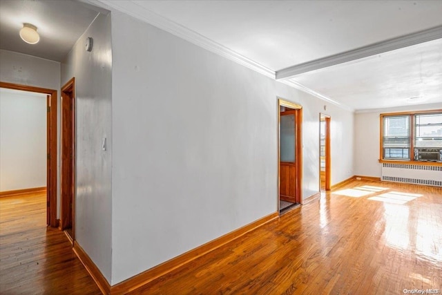 unfurnished room featuring radiator heating unit, hardwood / wood-style flooring, and ornamental molding