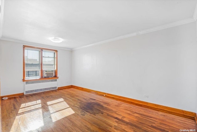 empty room featuring radiator heating unit, cooling unit, ornamental molding, and hardwood / wood-style flooring