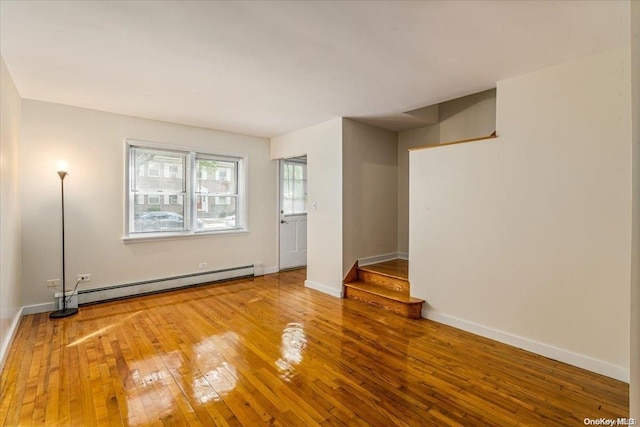 unfurnished room featuring a baseboard radiator and hardwood / wood-style flooring