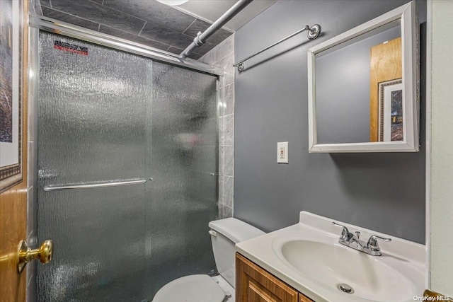 bathroom featuring toilet, vanity, and walk in shower