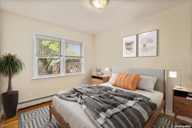 bedroom with hardwood / wood-style flooring and baseboard heating