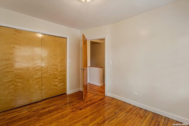 unfurnished bedroom with wood-type flooring and a closet