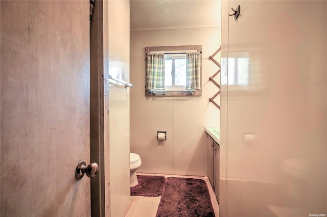 bathroom with vanity, toilet, and ornamental molding