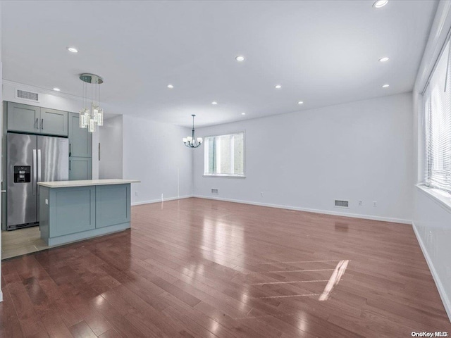 unfurnished living room featuring a chandelier and dark hardwood / wood-style floors