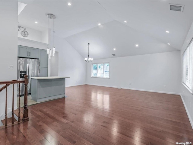 living room with dark hardwood / wood-style flooring, an inviting chandelier, and high vaulted ceiling