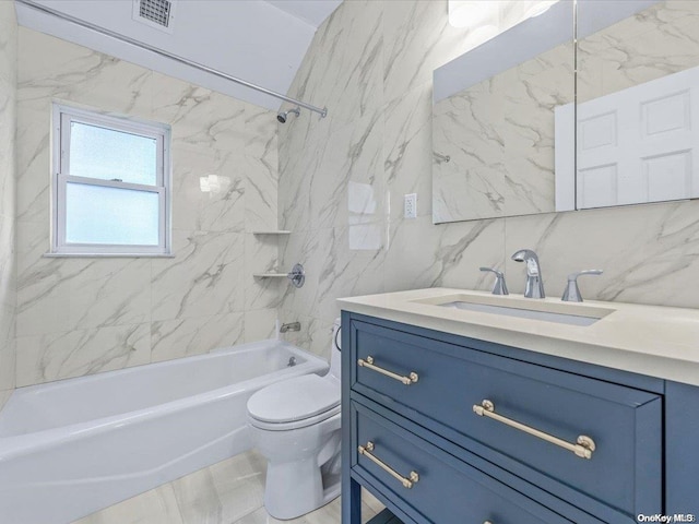 full bathroom featuring vanity, tiled shower / bath combo, tile walls, and toilet