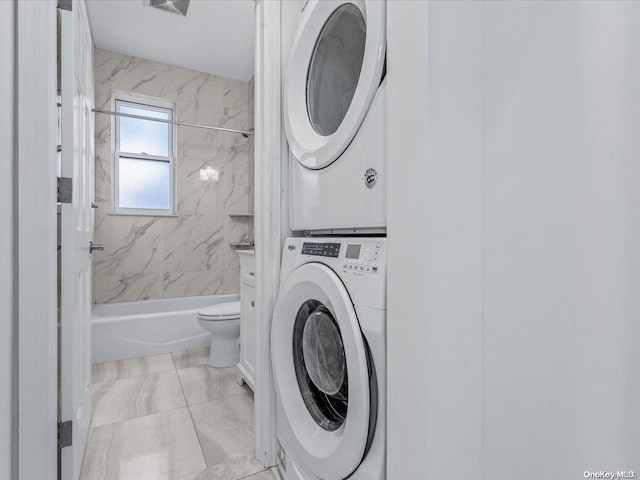 washroom featuring light tile patterned floors and stacked washer and dryer