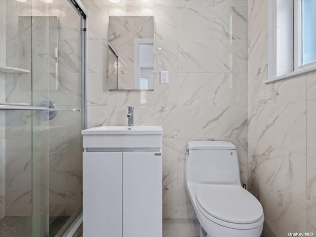 bathroom featuring vanity, a shower with door, toilet, and tile walls