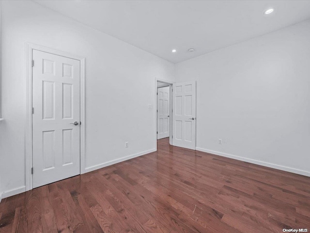 unfurnished bedroom with dark hardwood / wood-style flooring