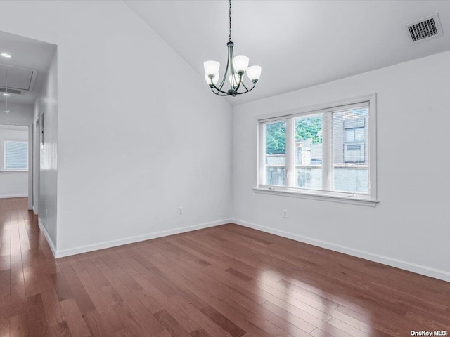 spare room with dark hardwood / wood-style flooring and a notable chandelier