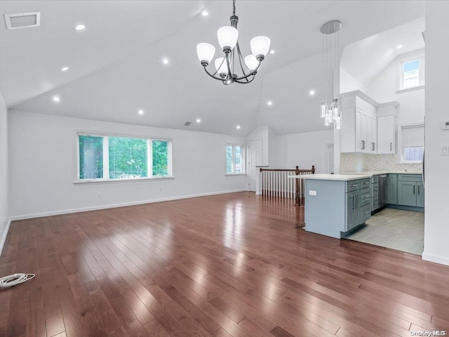 unfurnished living room featuring a healthy amount of sunlight, light hardwood / wood-style floors, and an inviting chandelier