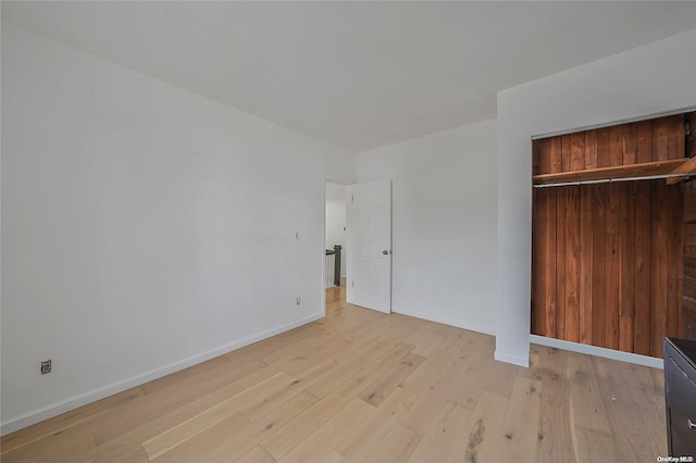 unfurnished bedroom with a closet and light wood-type flooring