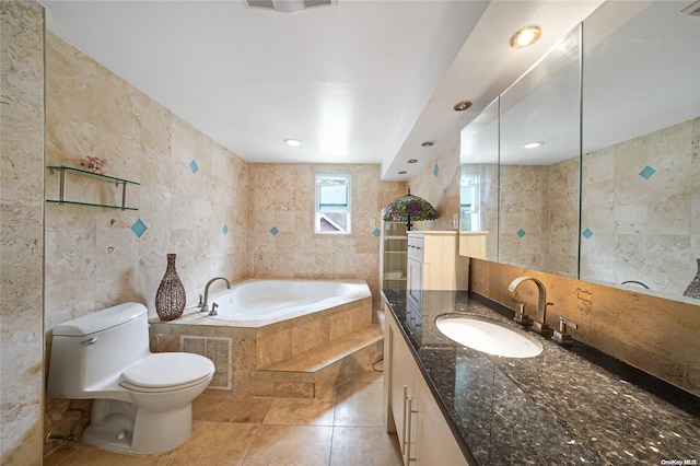 bathroom featuring vanity, tile patterned floors, a relaxing tiled tub, toilet, and tile walls