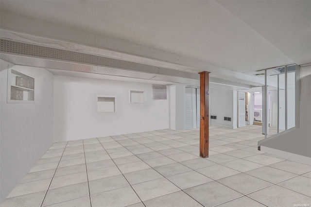 basement featuring light tile patterned floors and washer / dryer