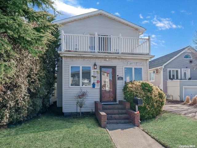 view of front facade with a balcony and a front lawn