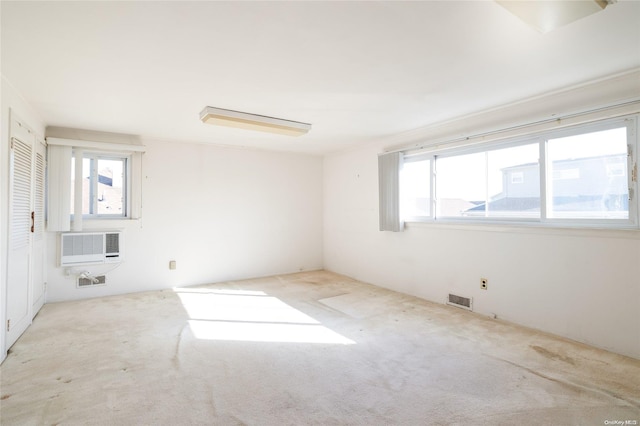 carpeted empty room featuring a wall mounted air conditioner and plenty of natural light