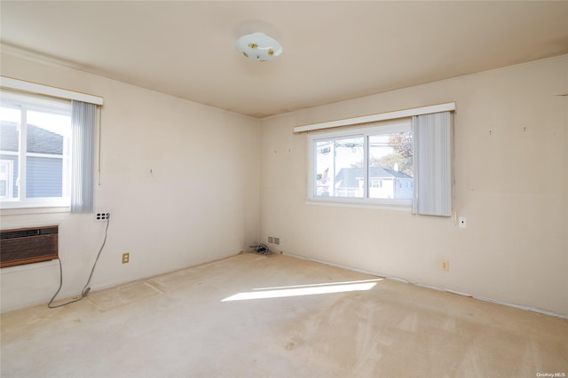 unfurnished room with a wealth of natural light, light carpet, and a wall mounted air conditioner