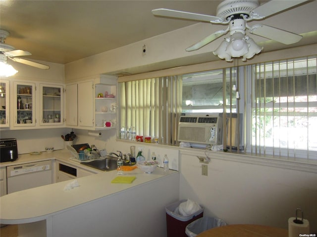 kitchen with white cabinets, a peninsula, light countertops, and a sink