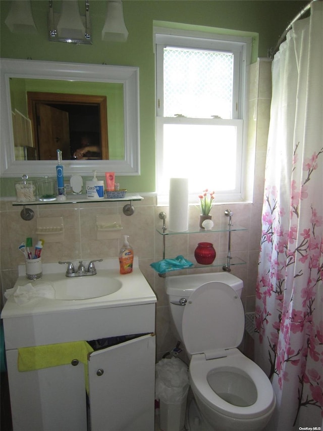 full bathroom with a shower with curtain, tile walls, toilet, and vanity