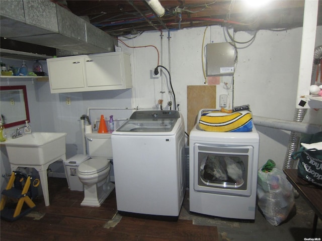 laundry room featuring dark wood-style flooring, cabinet space, and washing machine and clothes dryer