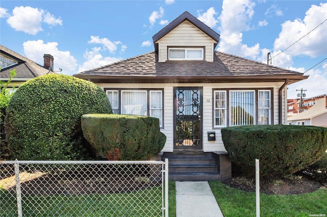 bungalow-style home with a front lawn