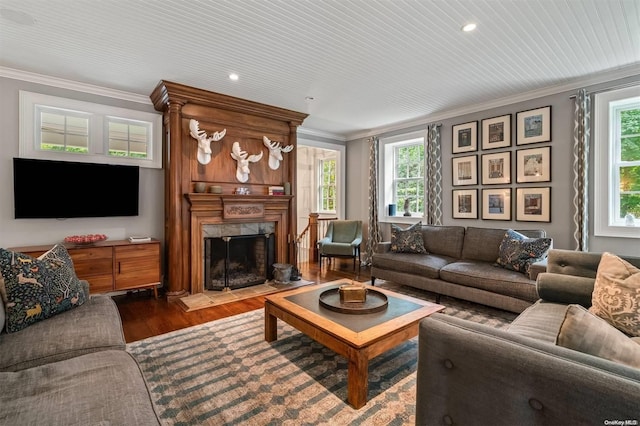 living room with crown molding, plenty of natural light, and hardwood / wood-style flooring