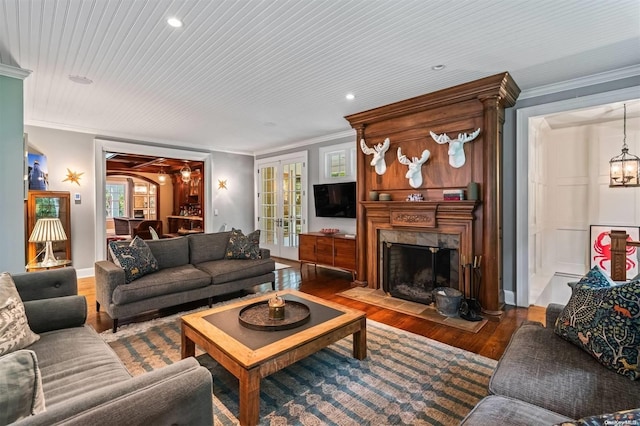 living room with hardwood / wood-style floors, a chandelier, and ornamental molding