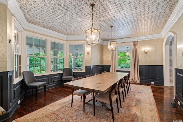 dining room featuring dark hardwood / wood-style flooring, lofted ceiling, crown molding, and an inviting chandelier