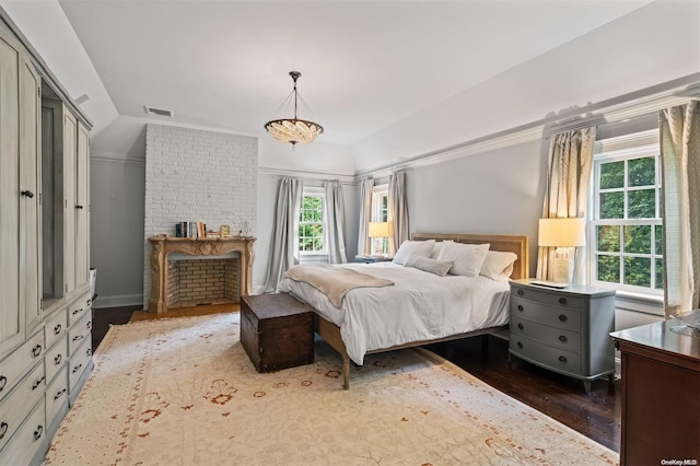 bedroom with hardwood / wood-style floors, a fireplace, and vaulted ceiling