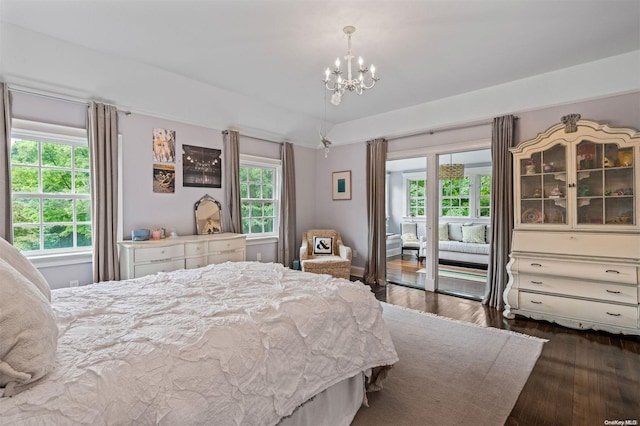 bedroom featuring a notable chandelier, access to exterior, dark wood-type flooring, and multiple windows